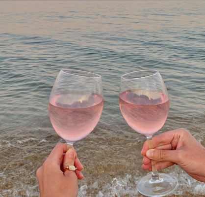 Two glasses of wine with the sea in the background.